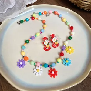 Colorful floral beaded necklace and festive red囍earrings set in a ceramic dish