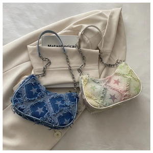 Detail of denim and fabric crescent bags with star patches and stylish metal chain straps