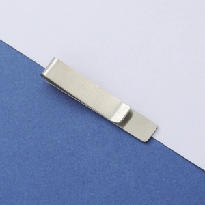 Close-up of matte brushed silver stainless steel tie clip showing metallic texture
