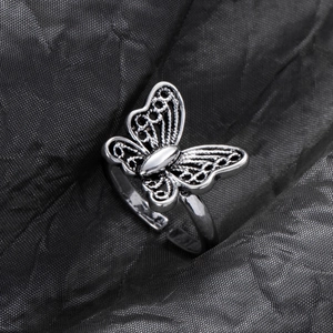 Macro shot of an antique silver butterfly ring featuring intricate hollow metal work