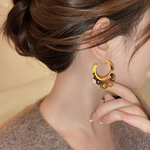 Tiger eye stone beaded geometric C-shaped hoop earrings with gold finish on model