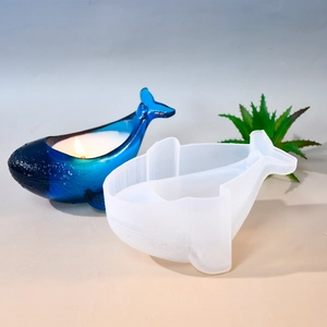 Detail view of a whale-shaped silicone mold and a finished blue candle craft product