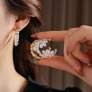 Gold-plated C-shaped earrings with textured lava pattern and clustered white pearls