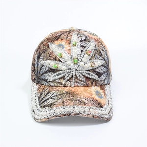 Detail of baseball cap featuring rhinestone cannabis leaf and pearl-encrusted brim decor