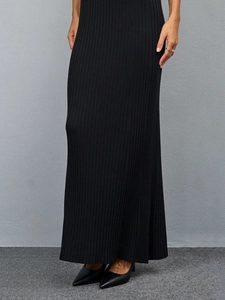 Detail of black ribbed knit fabric on a slim-fit maxi dress for a sleek silhouette