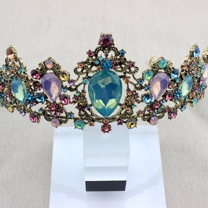 Macro shot of vintage gold crown with colorful rhinestones and turquoise teardrop gem