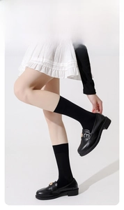Detail view of black compression socks showing gradient pressure design for leg shaping