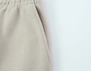 Vue détaillée de la taille élastique et de la couture de la poche sur le pantalon beige