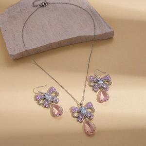 Elegant silver bow jewelry set with pink teardrop crystal necklace and earrings