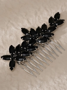 Macro detail of silver bridal hair combs with black marquise gemstones and floral design