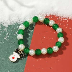 Christmas beaded bracelet with reindeer charm and green pearls on a festive background