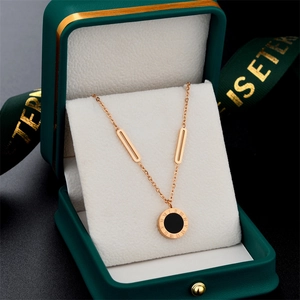 Rose gold Roman numeral necklace with black disc pendant and green jewelry box