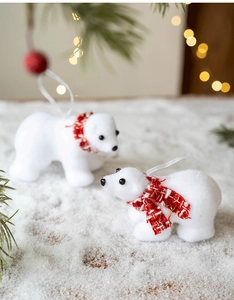 Close-up of cute flocked white polar bear ornaments with festive red scarves for Christmas