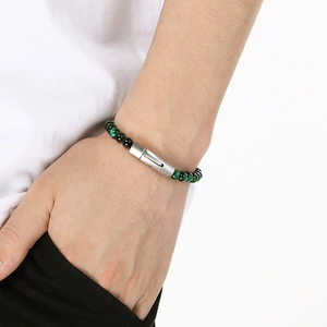 Close-up of green tiger eye beaded bracelet with stainless steel clasp on male wrist