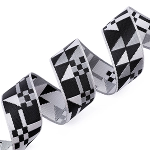Detailed view of wide woven shoulder strap featuring black and white geometric patterns