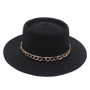 Detail view of black straw sun hat featuring elegant flat top and golden chain trim