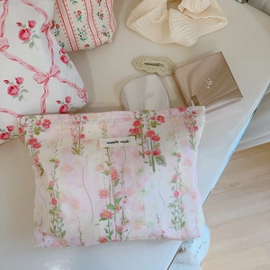 Détail de la trousse de maquillage en coton floral avec étiquette et motifs de fleurs roses