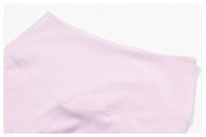 Detailed close-up of high-waisted yoga leggings with double-needle stitching in pale pink