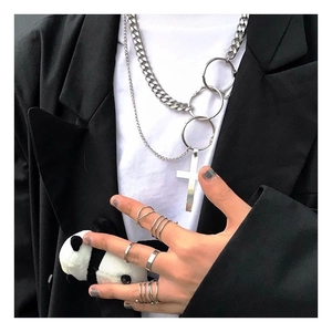 Close-up of hip-hop style silver metal cross pendant and layered cuban chain necklace