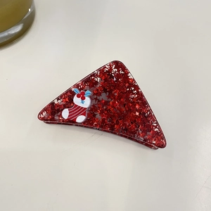 Detail of red triangular hair claw with star sequins and Christmas stocking design