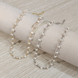 Elegant 18K gold and silver plated freshwater pearl necklaces on a gray display