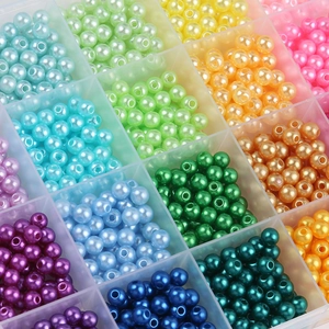 Multi-colored 6mm ABS round pearl beads organized in a 28-grid clear plastic storage box