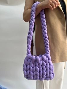 Side view of a chunky purple hand-knitted tote bag featuring thick oversized braided yarn