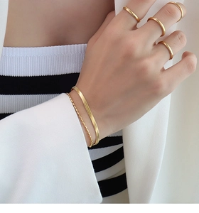 Detail von 18K vergoldeten Titanstahl-Schlangenketten und Perlenarmbändern für Damen