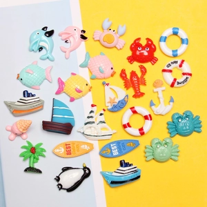 Flat lay of colorful resin ocean charms including anchor, dolphin, and surfboard