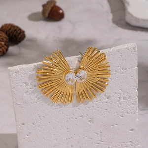 Boucles d'oreilles soleil dorées avec zircone cubique sur support texturé blanc élégant