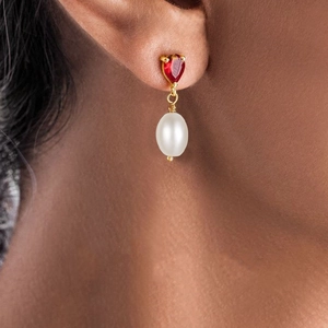 Detail of s925 silver long earring with heart red gemstone and elegant white pearl drop