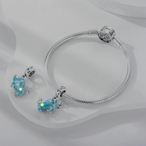 Detail of silver snake chain bracelet featuring blue enamel Taurus bull head charms
