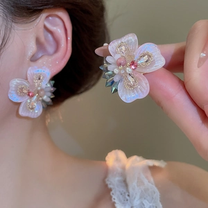 Detailed close-up of pink crystal flower earrings with pearls and rhinestones