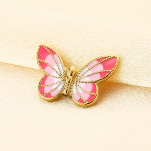 Vista macro di un ciondolo a farfalla in smalto rosa e finitura dorata per gioielli DIY