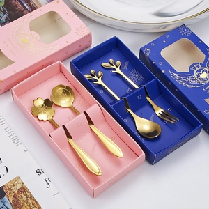 Close-up of golden stainless steel flower and branch design spoons in premium gift boxes