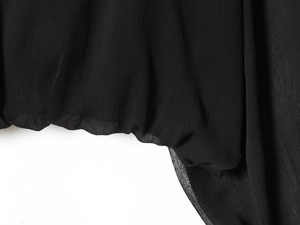 Detalle de tela de gasa negra transparente con textura plisada elástica en la manga