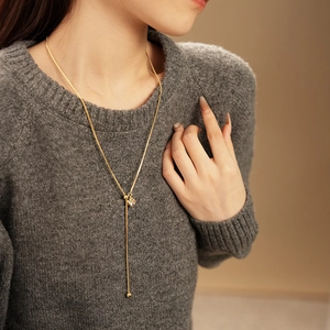 Detail of gold plated Y-shaped tassel necklace with zircon crystal and snake chain on model
