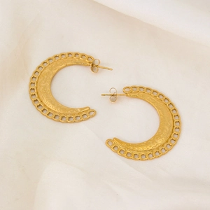 Gros plan détaillé de boucles d'oreilles croissant dorées avec texture de chaîne gravée