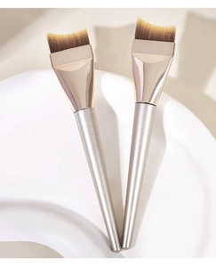 Close-up of crescent foundation brushes with champagne gold handles and soft gradient bristles