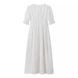 Détails de broderie florale sur une robe blanche à col en V et manches courtes