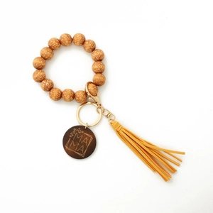 Detailed view of leopard print beads, yellow tassel and MAMA engraved wooden disc keychain