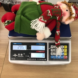 Detailed view of Christmas elf plush toy weighing 295 grams on a digital scale