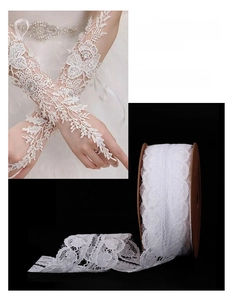 Macro view of 32mm wide white lace ribbon showing delicate wavy flower texture, length 9m