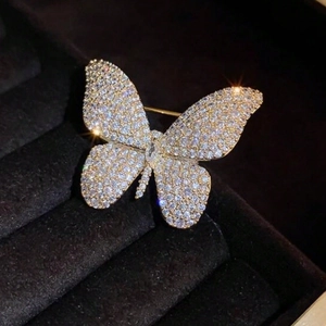 Elegant gold butterfly brooch with shimmering zircons on dark velvet jewelry box