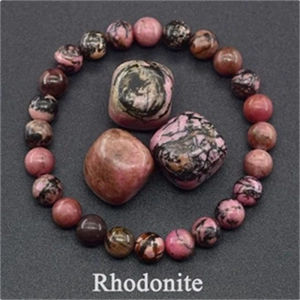 Elastic beaded rhodonite bracelet with natural pink and black stone chunks on dark background