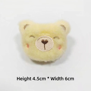 Detail of yellow plush bear head with embroidery, dimensions height 4.5cm width 6cm