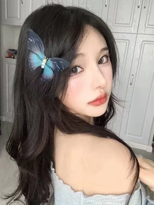 Close-up of blue gradient mesh butterfly hair clip with pearls worn by a model