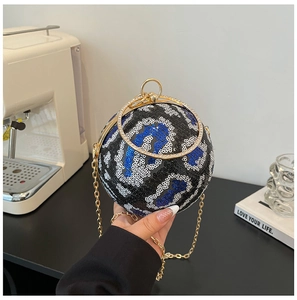 Detail of sequined spherical evening bag with leopard pattern and gold metal handle