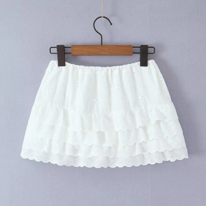 Détail d'une jupe blanche à volants en dentelle avec broderie et taille élastique
