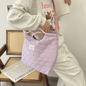 Sac fourre-tout matelassé lavande avec bretelles roses porté par un mannequin stylé